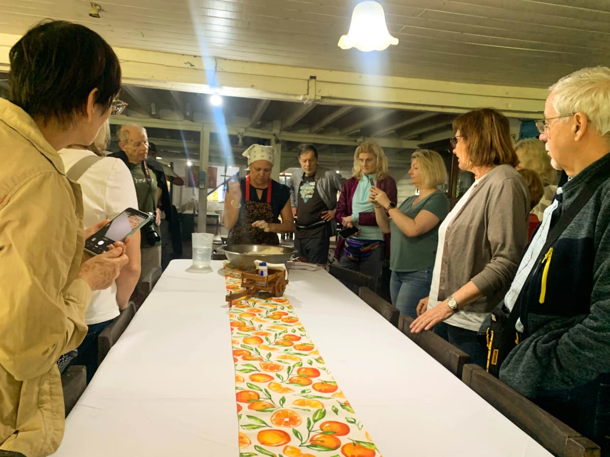 Group of visitors watching a traditional tortilla making demonstration