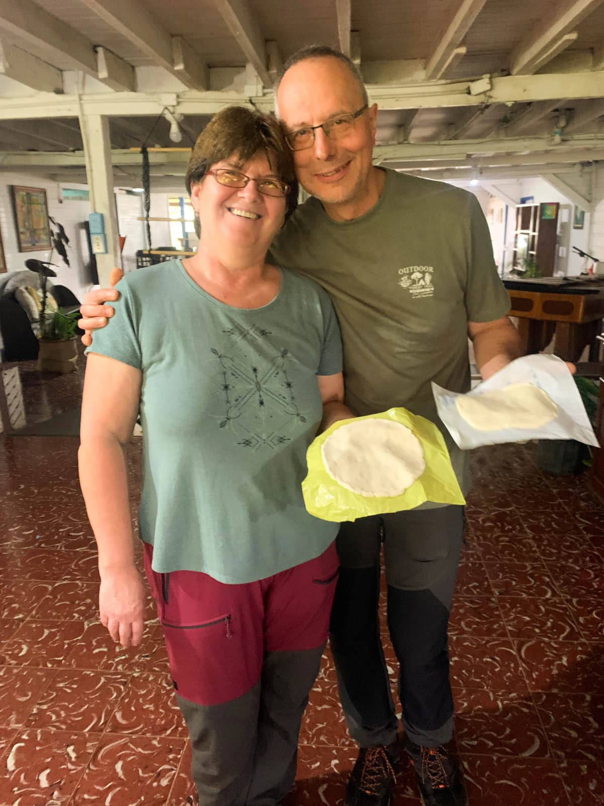 Tourist couple smiling and showing their handmade pressed tortillas