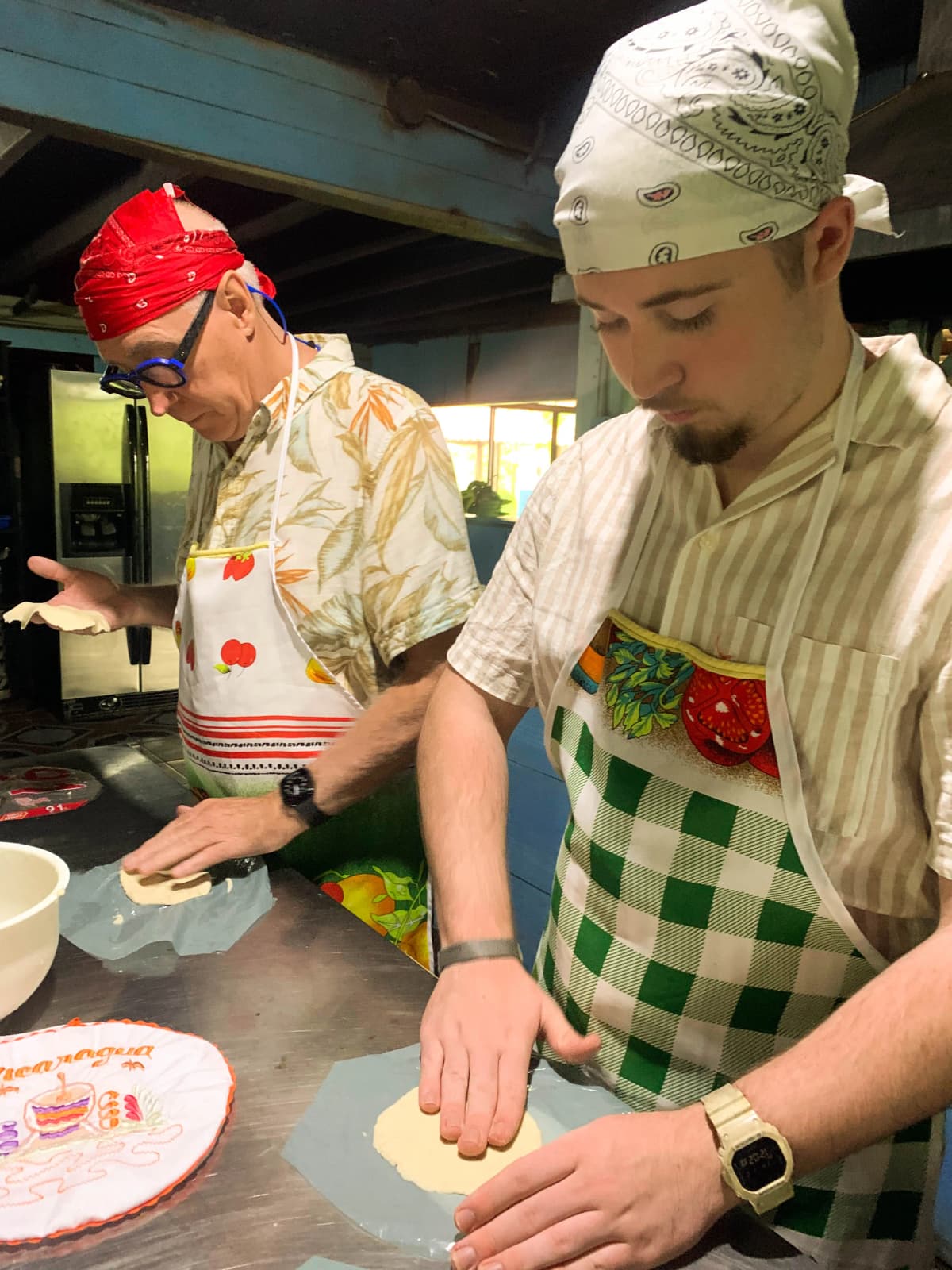 Visitors pressing and shaping corn tortilla dough during the class