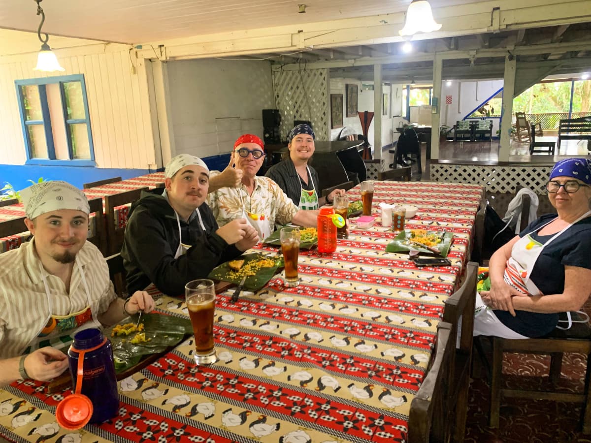 Group of visitors sitting at the table enjoying the food prepared in class