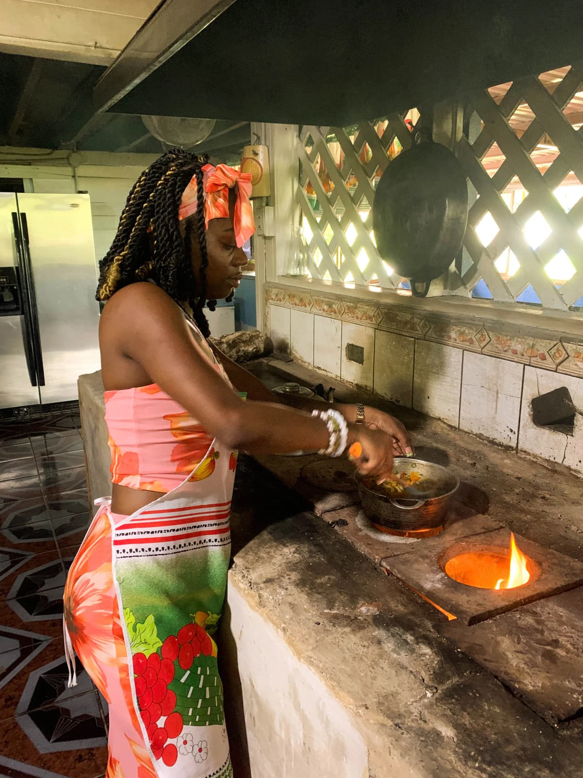 Visitor cooking directly over the wood-fired stove in the rustic kitchen