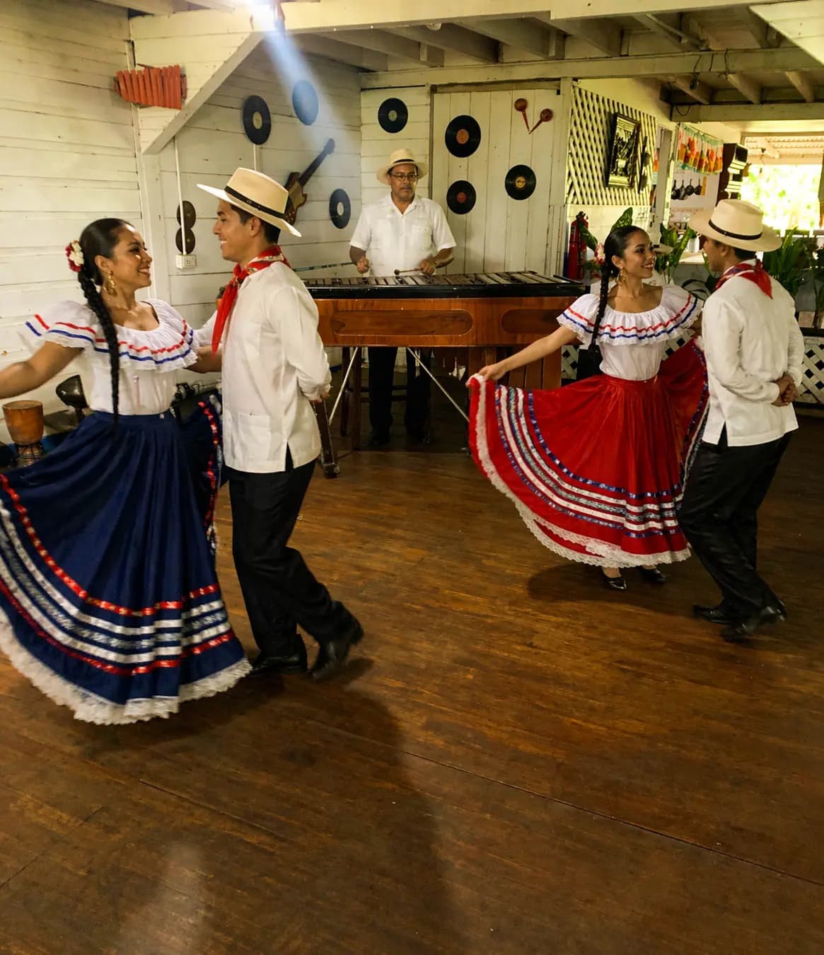 Couples of dancers in Costa Rican folkloric costumes performing with live marimba music
