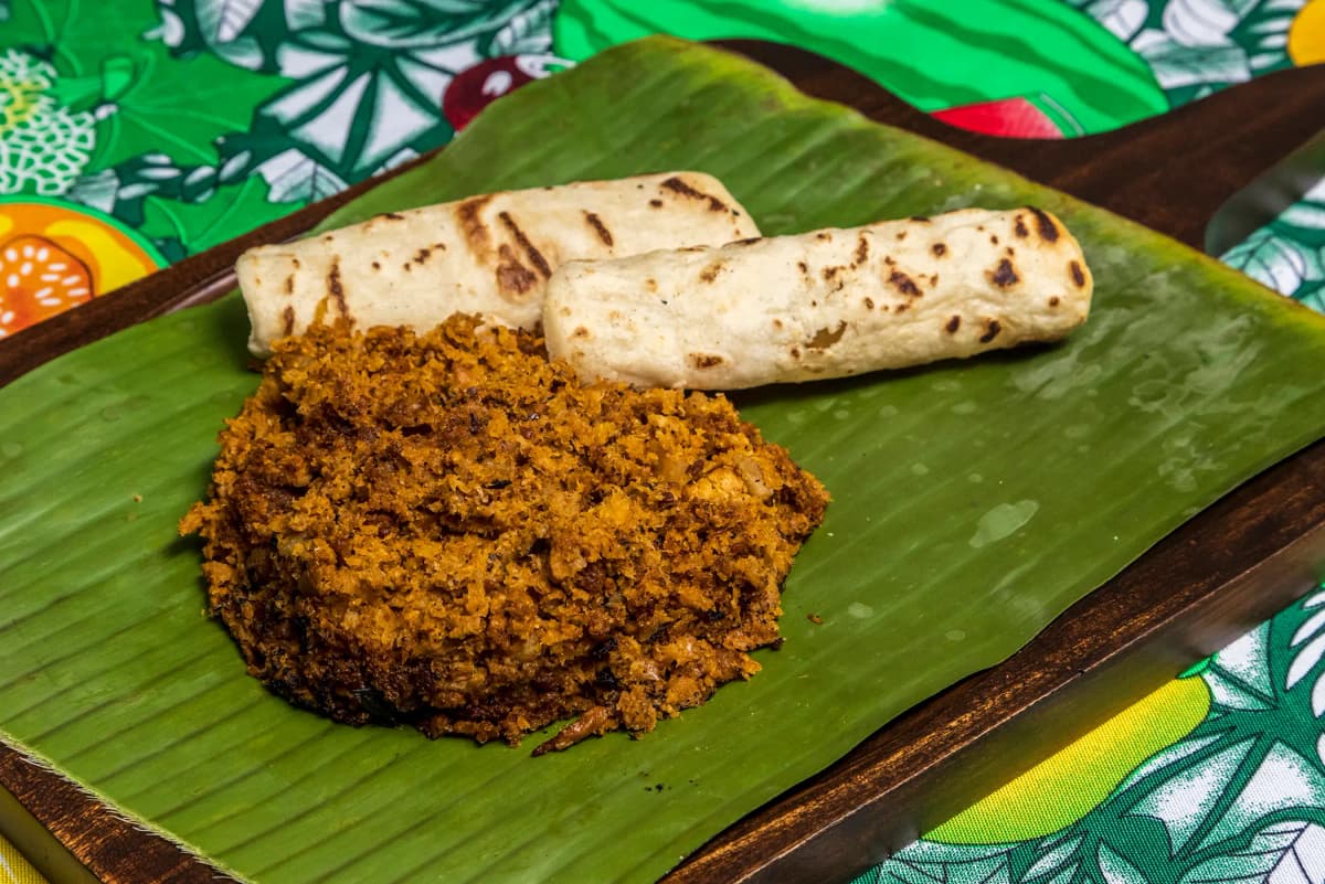 Traditional Costa Rican picadillo served on a banana leaf with handmade tortillas