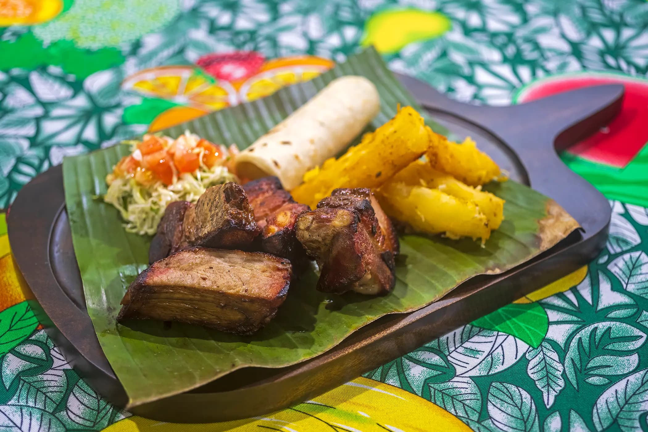 Pork chunks with cassava served on banana leaf