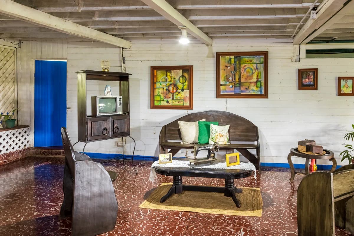 Wide view of the antique rustic living room with vintage TV and blue door