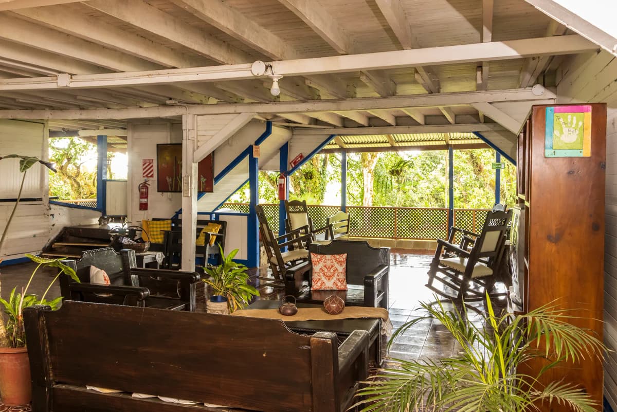 Overview of La Casona main hall with white wooden architecture and rustic beams