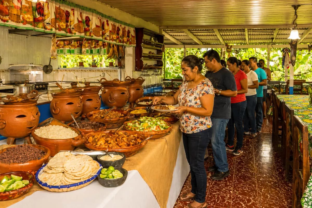 Visitors serving themselves at the traditional rustic buffet with traditional pots and dishes