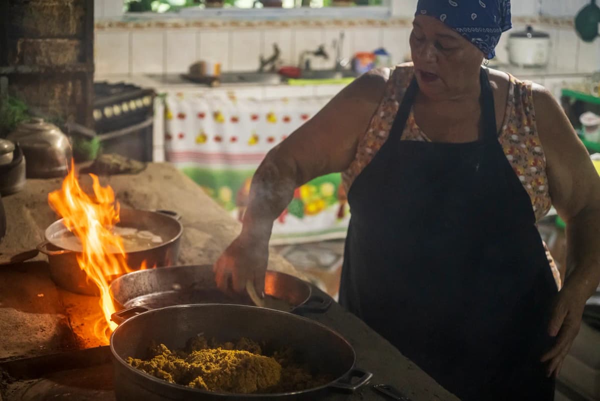 Traditional cook preparing food on the wood-fired stove with open flames