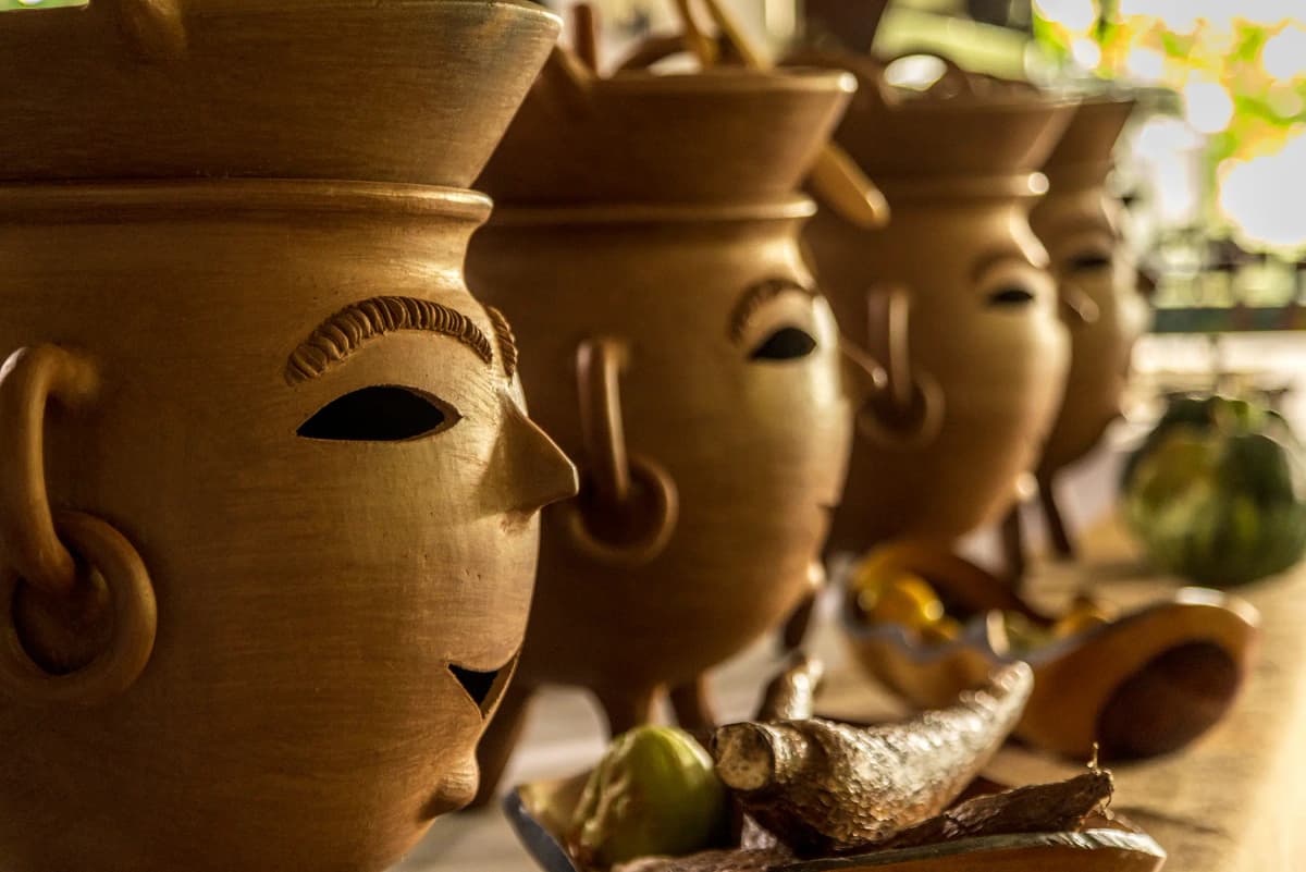 Close-up of traditional handcrafted pots sculpted with faces